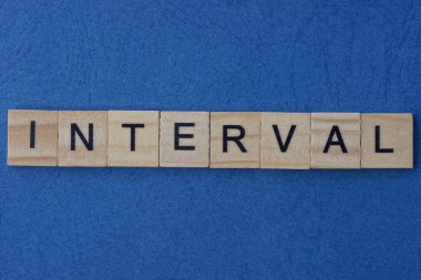 Küçük ahşap kare harflerin gri kelime aralığı üzerine metin mavi kağıt masa üzerinde yatar