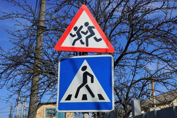 Twee Verkeerstekens Een Voetgangersovergang Voorzichtigheid Kinderen Achtergrond Van Grijze Takken — Stockfoto