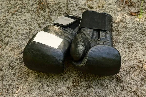 Два Черных Спортивных Боксерских Перчатки Кожи Лежат Сером Песке Улице — стоковое фото