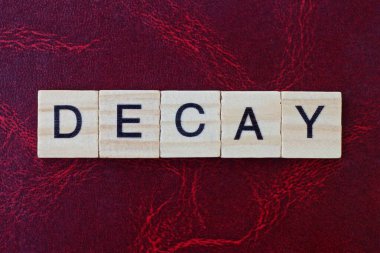 Kelime, kırmızı bir masanın üzerinde siyah yazı tipi olan gri ahşap harflerden bozunur.