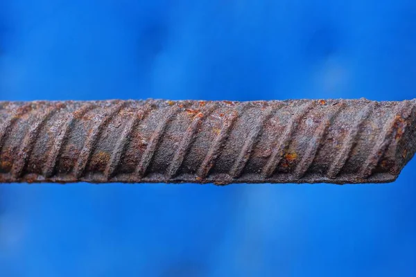 Uma Haste Ferro Marrom Longo Vergalhões Ferrugem Fundo Azul — Fotografia de Stock