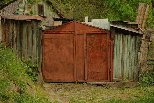 Geschlossenes Rotes Rostiges Garagentor Aus Eisen Und Holzzaun Einer Ländlichen — Stockfoto