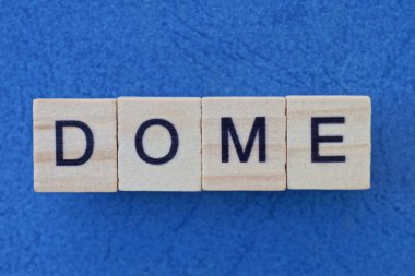  Mavi arka planda siyah yazı tipi olan küçük kare ahşap harflerle kısa gri kelime kubbesi.