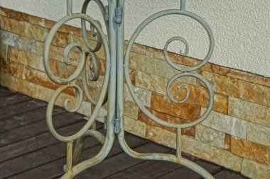 Gri demirden yapılmış gri metal masa bacağı kahverengi bir duvara karşı dövülmüş.