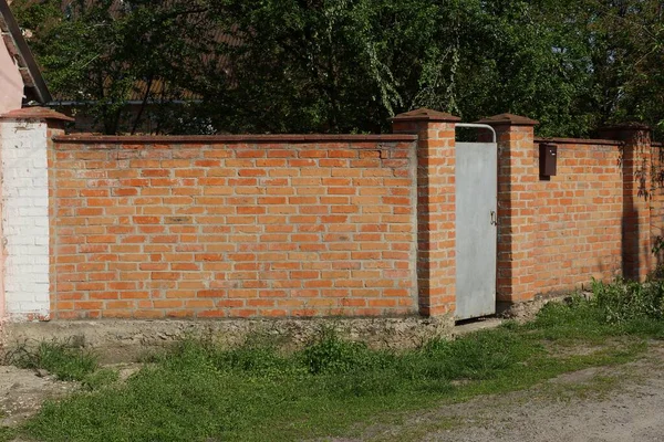Красная Кирпичная Стена Забора Серая Железная Дверь Улице Зеленой Траве — стоковое фото