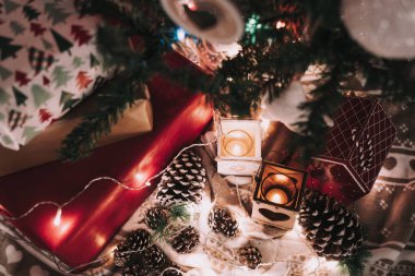 Mumlarla, kozalaklarla ve yılbaşı ışıklarıyla Noel süslemesi.