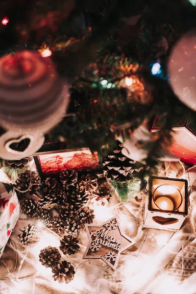 Vánoční dekorace se svíčkami a vánočními světly. S jedlovými kužely a hvězdou s vánočními pozdravy. — Stock fotografie