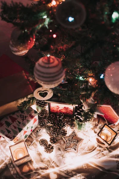 Vánoční dekorace se svíčkami a vánočními světly. S jedlovými kužely a hvězdou s vánočními pozdravy. — Stock fotografie
