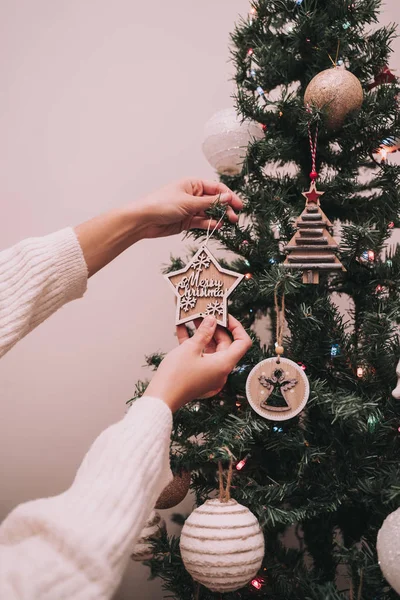 Una persona está decorando el árbol de Navidad. La persona está colgando una estrella de Navidad con un saludo de Navidad. Primer plano . — Foto de Stock