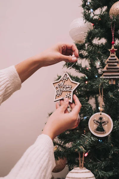 Una persona está decorando el árbol de Navidad. La persona está colgando una estrella de Navidad con un saludo de Navidad. Primer plano . — Foto de Stock