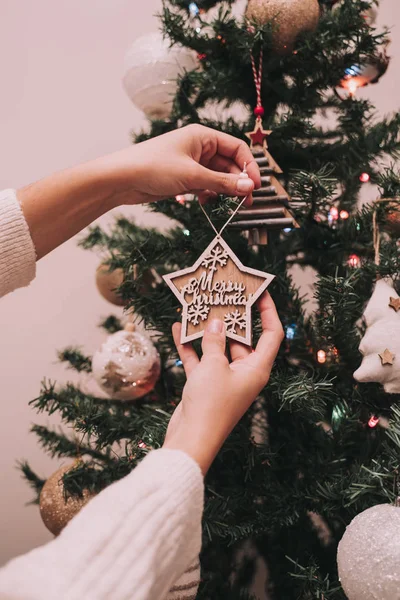 Jeden člověk zdobí vánoční stromeček. Ten člověk věší vánoční hvězdu na vánoční pozdrav. Zavřít. — Stock fotografie