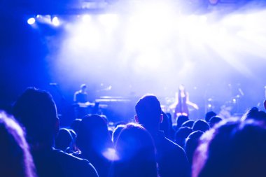 İnsanlar sahnede şarkıcının keyfini çıkarıyorlar. Onlar konserde müzik dinliyorlar. Seçici odak
