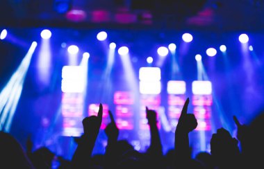 Bir konser sırasında bir kalabalık kollarını kaldırdı. Onlar müzikten zevk alıyorlar. Seçici odak.