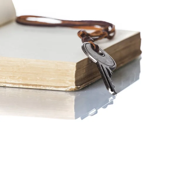 Schlüssel und altes Buch auf weißem Hintergrund — Stockfoto