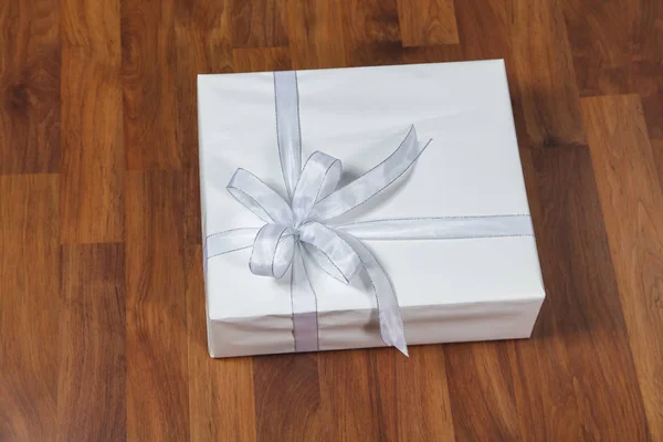 White gift box on a wooden background — Stock Photo, Image