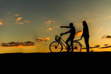 Silhouette tatlı çift aşk mutlu zamanında ve bisiklet içinde bea