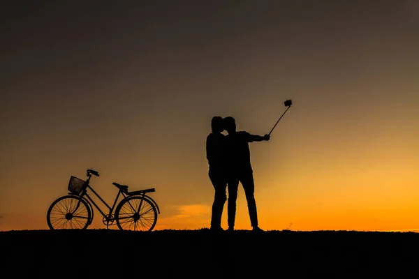 Silhouette of sweet couple in love happy time and bicycle in bea — Stock Photo, Image