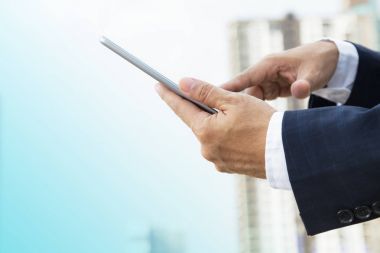 Elleri açık dijital tablet üzerinde çalışan iş adamı