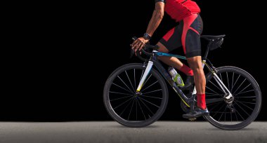 Adam siyah arka plan üzerine bir yolda bisikletle