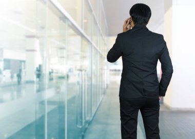 Bir cep telefonu üzerinde modern bir ofis kullanarak çekici iş adamı