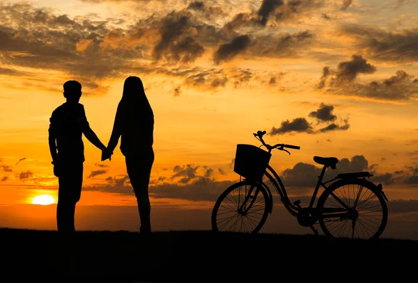 Silueta de dulce pareja enamorada tiempo feliz y bicicleta en bea —  Fotos de Stock