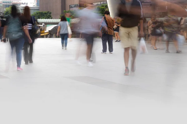 Mensen lopen in motion blur in de stad — Stockfoto
