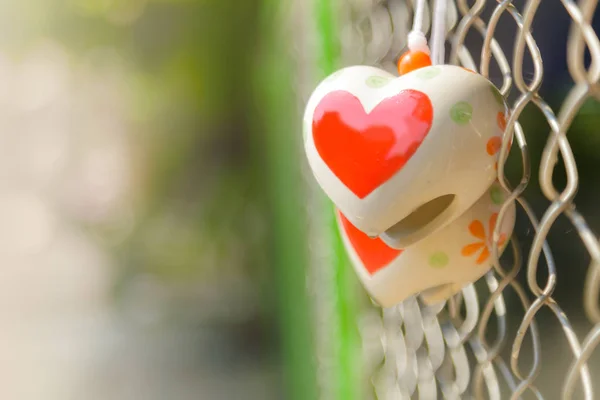 Heart toys on the cage metal net — Stock Photo, Image