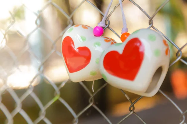 Giocattoli del cuore sulla rete metallica della gabbia — Foto Stock