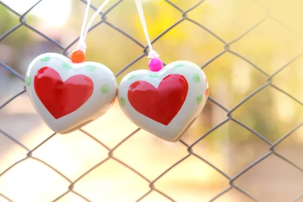 Giocattoli del cuore sulla rete metallica della gabbia — Foto Stock