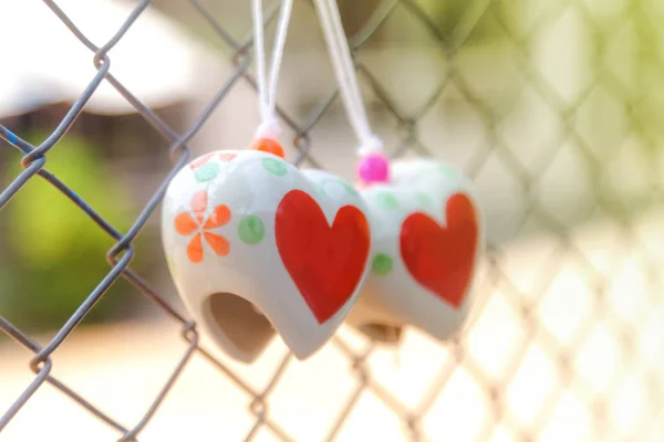 Heart toys on the cage metal net — Stock Photo, Image