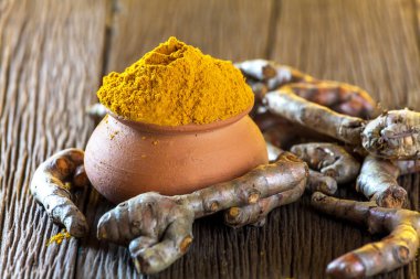 Ahşap arka plan üzerinde zerdeçal kökü