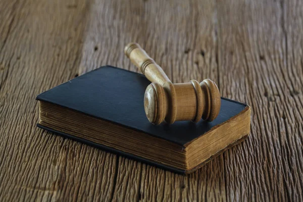 Judge's gavel with old book on old wood table — Stock Photo, Image