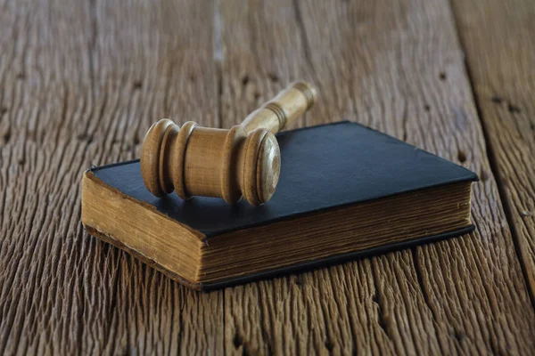 Judge's gavel with old book on old wood table — Stock Photo, Image