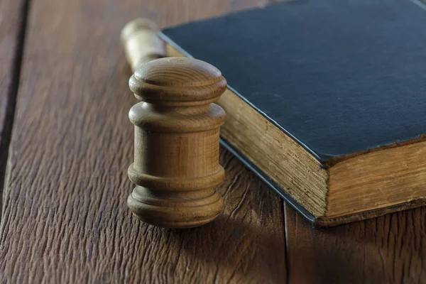 Judge's gavel with old book on old wood table — Stock Photo, Image