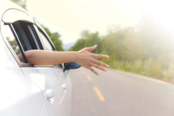 Kvinna hand på bilfönstret på en landsväg — Stockfoto