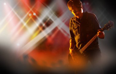 Silhouette elektro gitar oyuncu ve şarkıcı bir sahnede canlı