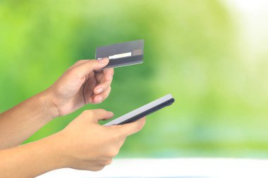 Kredi kartı ile O smartphone ile kadın el görünümünü kırpılmış
