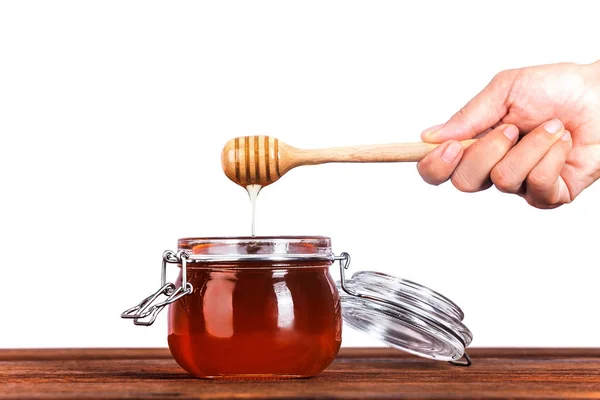 Скляна банка меду з дерев'яним мрякою на білому тлі — стокове фото