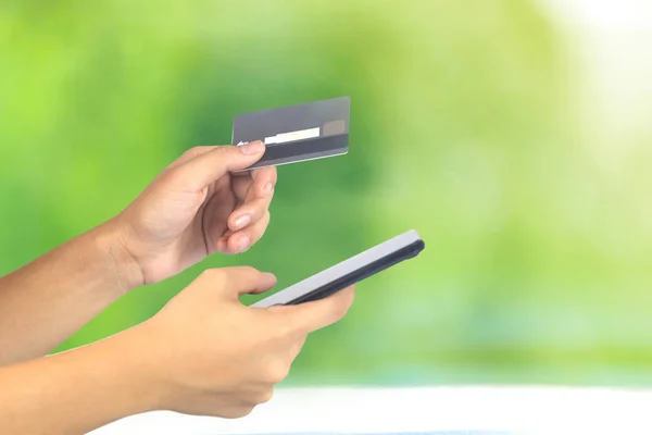 Vista cortada das mãos da mulher usando smartphone com cartão de crédito, O — Fotografia de Stock