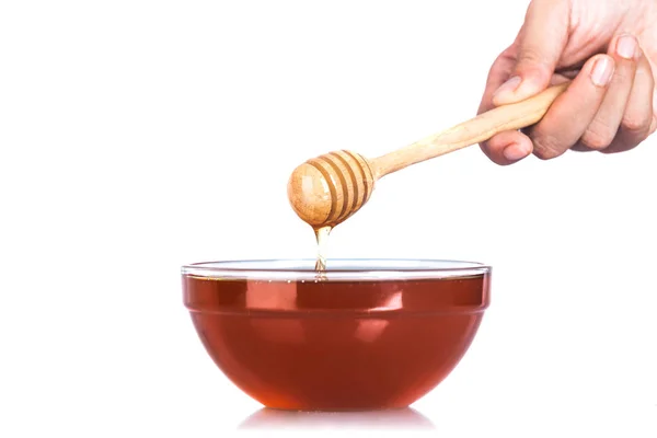 Скляні чаші меду з дерев'яними drizzler на білому тлі — стокове фото