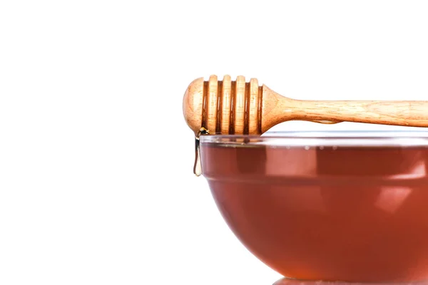 Glasskål med honung med trä drizzler på vit bakgrund — Stockfoto