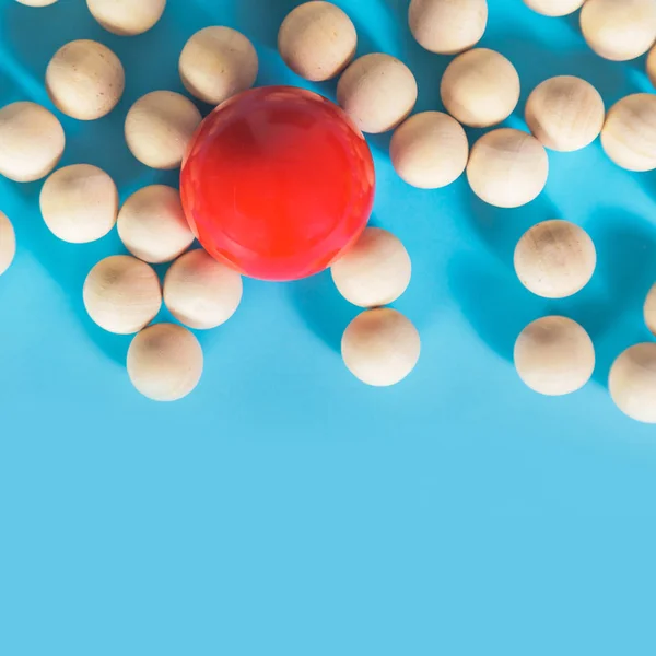 Koncepce vedení, červený míček a dřevěné koule s stín na modré — Stock fotografie