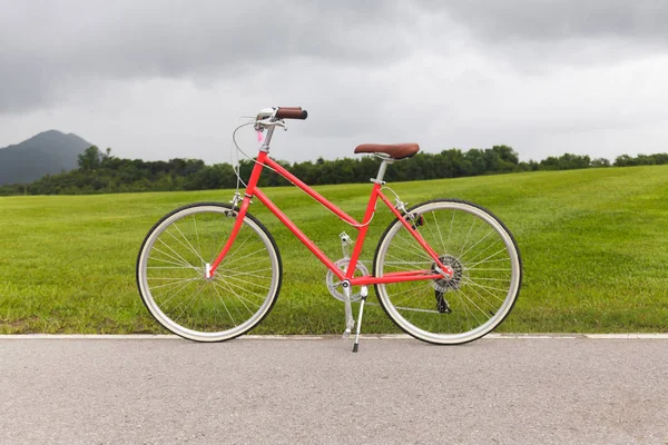 Красный велосипед в саду — стоковое фото