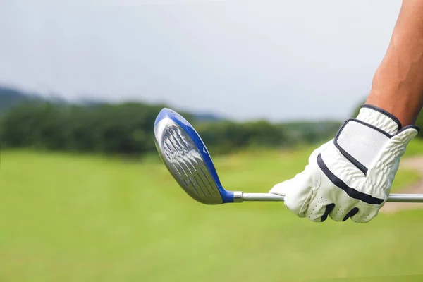 Golf player holding a golf club on golf course