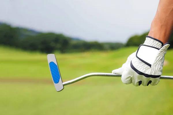 Golf-spelare håller en golfklubba på golfbana — Stockfoto