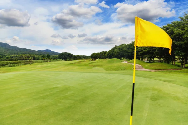 Drapeau jaune sur le beau terrain de golf avec ciel bleu — Photo