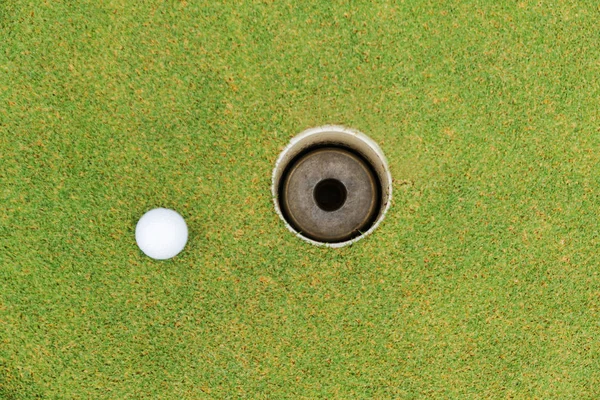 Furo de golfe e bola de golfe na grama verde no campo de golfe — Fotografia de Stock