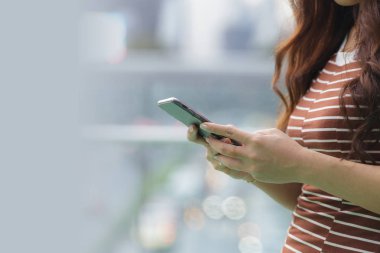 Kadın el bulanık backgro ile akıllı telefon tutarak yakın çekim