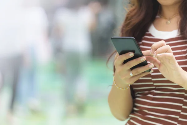 Close up of woman hands holding smart phone with blurred backgro — Stock Photo, Image