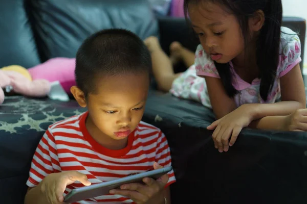 ภาพตัดของเด็กชายและเด็กผู้หญิงที่ใช้แท็บเล็ตดิจิตอลที่ ho — ภาพถ่ายสต็อก